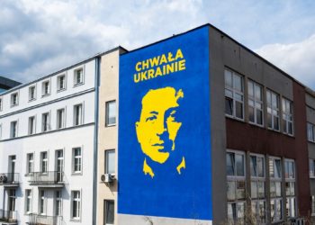 a building with a blue and yellow mural of a man's face