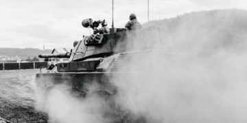 grayscale photo of soldiers on battle tank