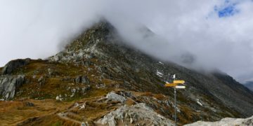 a very tall mountain with a sign in the foreground