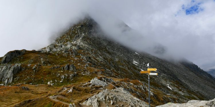 a very tall mountain with a sign in the foreground