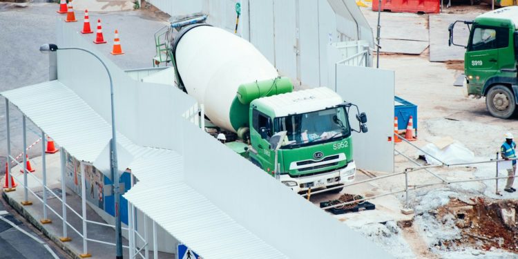 green and white mixer truck at the construction site