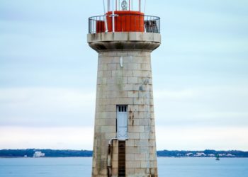 white and red lighthouse on body of water during daytime